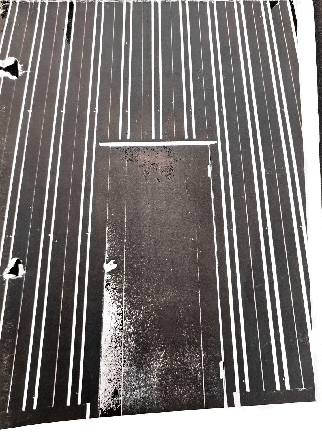 Black-and-white photo of a multi-lane running track with a rectangular marked field area.